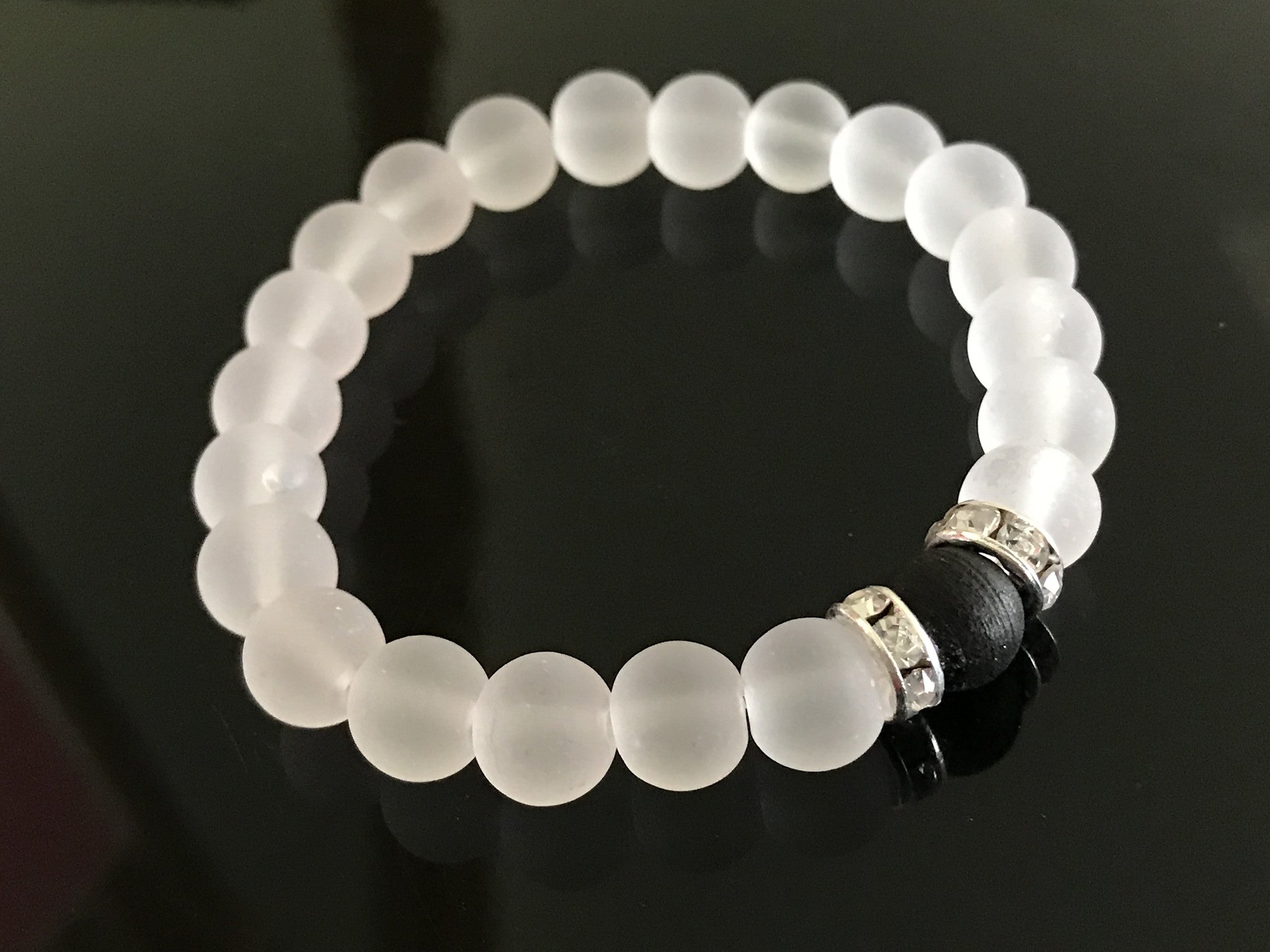 White frosted glass beads with a black beads and two rhinestone beads